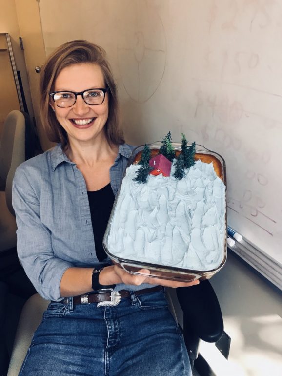 Harriet holds up a "sea level rise cake" baked and designed by Laura Davis of EarthLab. The cake celebrated the release of the 2018 Sea Level Rise Projections developed as part of the Washington Coastal Resilience Project.