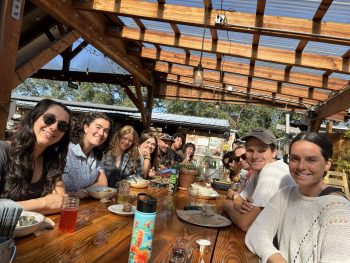A group of fellows sitting around a table outside