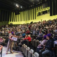 A full audience sit in a theater
